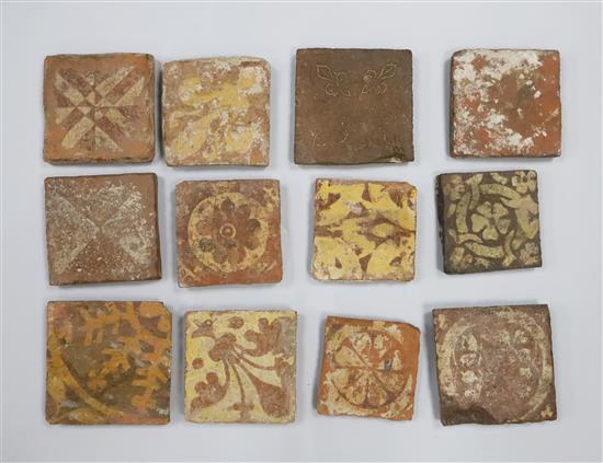 Twelve medieval terracotta tiles, ranging from 10.4 -13cm wide